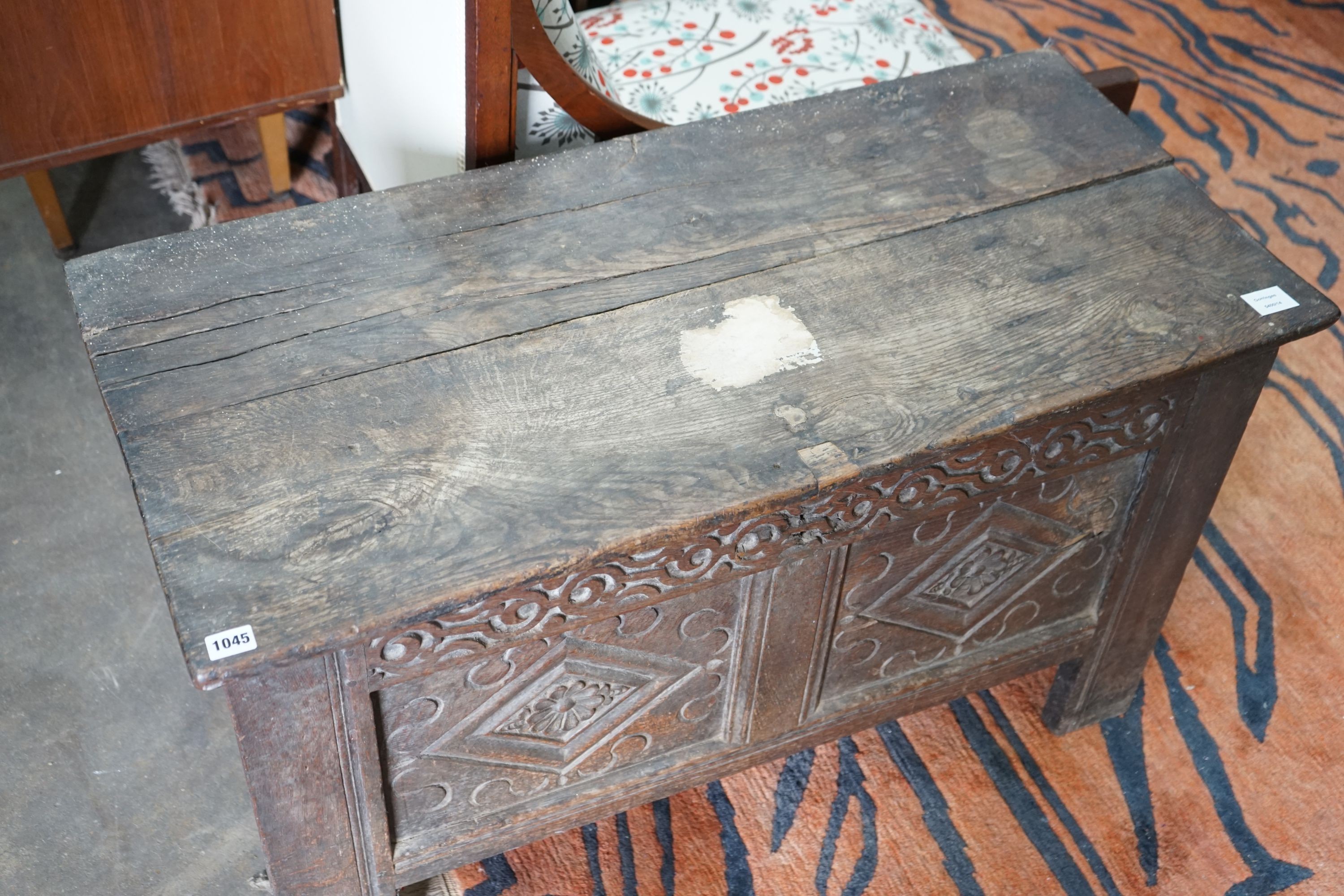 A small 18th century carved oak coffer, with a carved panelled front, length 102cm, depth 47cm, height 57cm